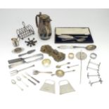 A quantity of assorted silver plated wares to include asparagus tongs, toast rack, knife rests, fish