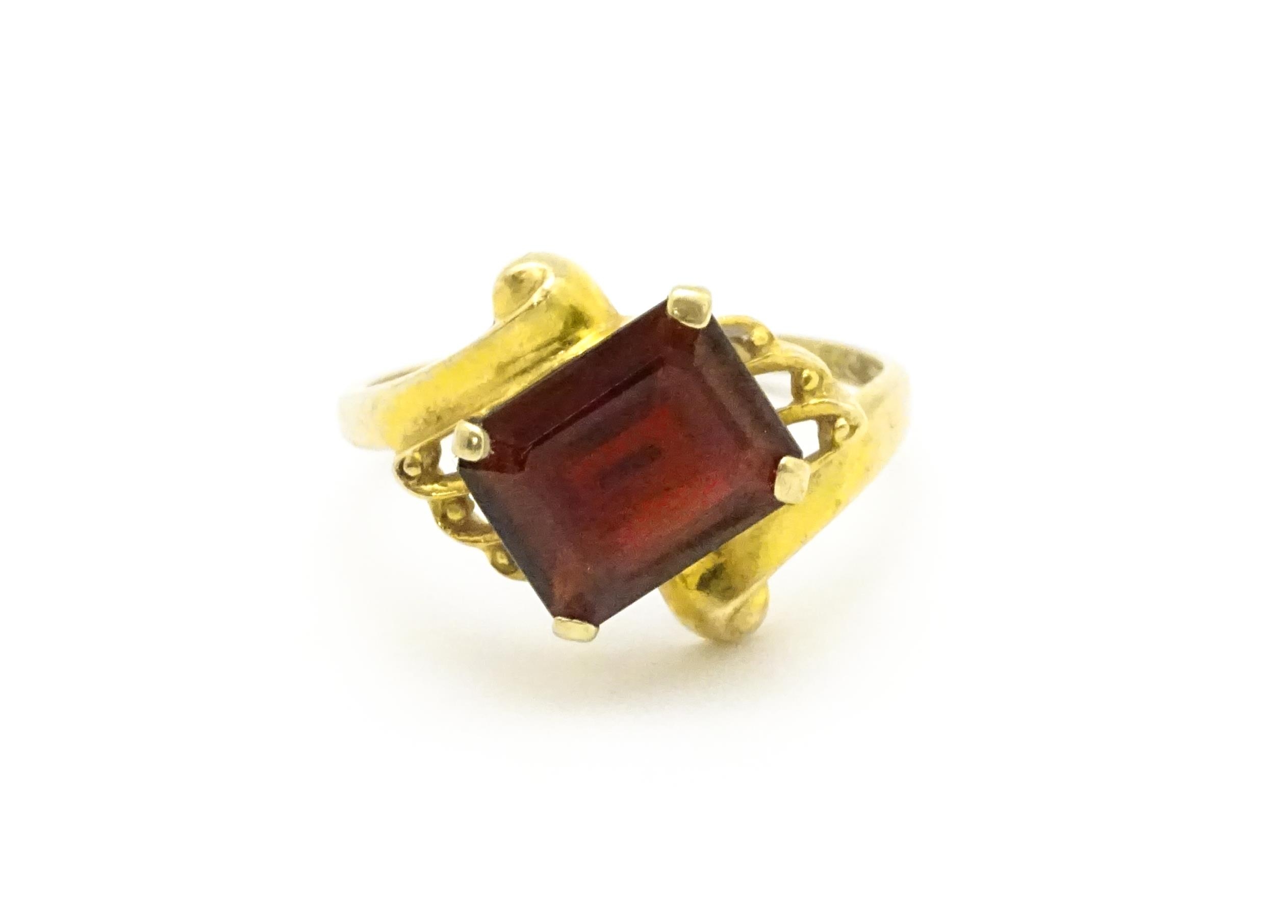 A 9ct gold ring set with central garnet. Ring size approx. O 1/2 Please Note - we do not make