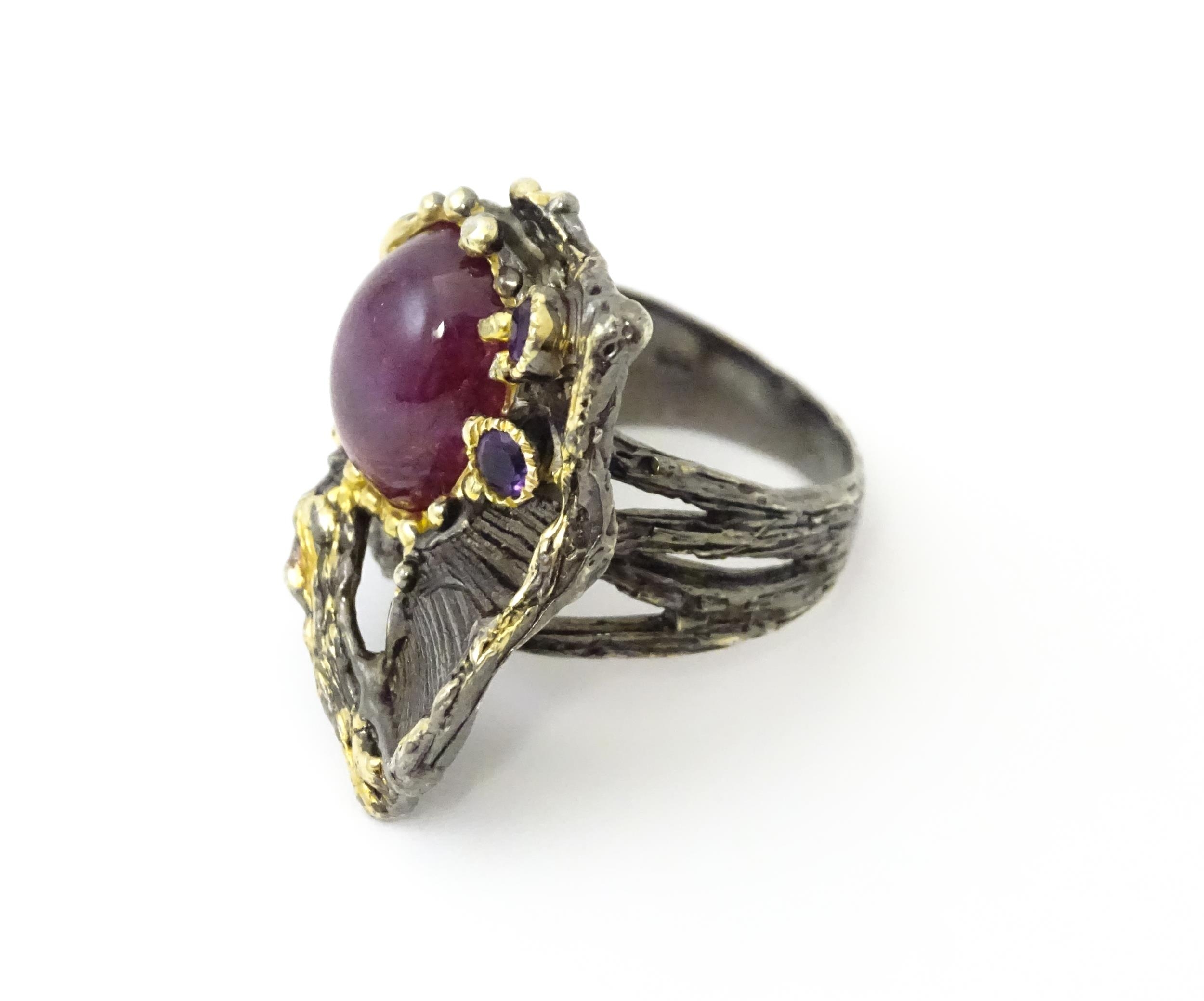 A silver ring set with ruby cabochon and two amethysts, with gilt highlights. Ring size approx. O - Image 4 of 5