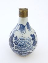 A Chinese blue and white bottle vase decorated with flowers and foliage, with a metal mount. Approx.