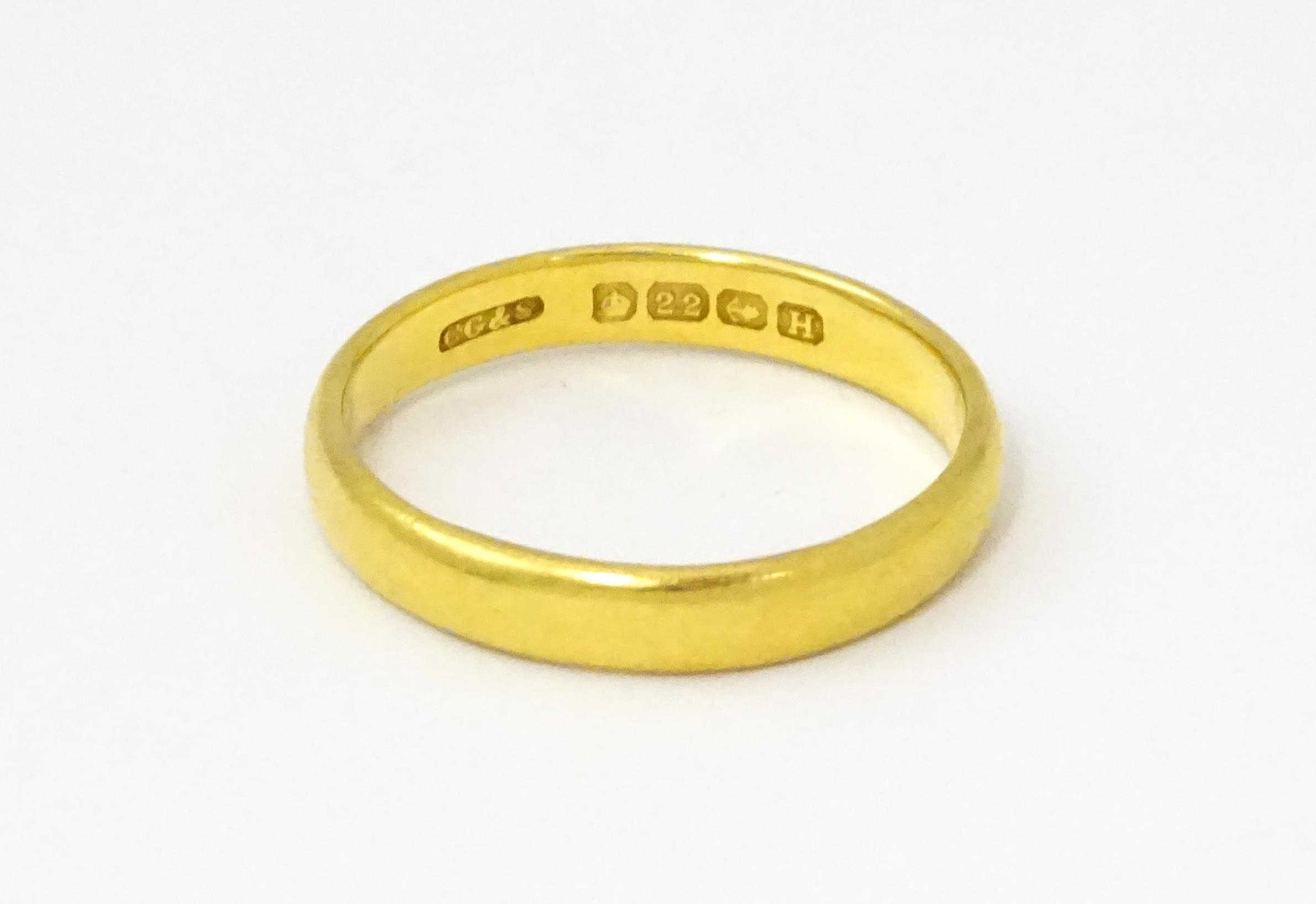 A 22ct gold ring / wedding band. Ring size approx. L 1/2 Please Note - we do not make reference to