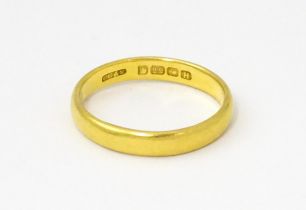 A 22ct gold ring / wedding band. Ring size approx. L 1/2 Please Note - we do not make reference to