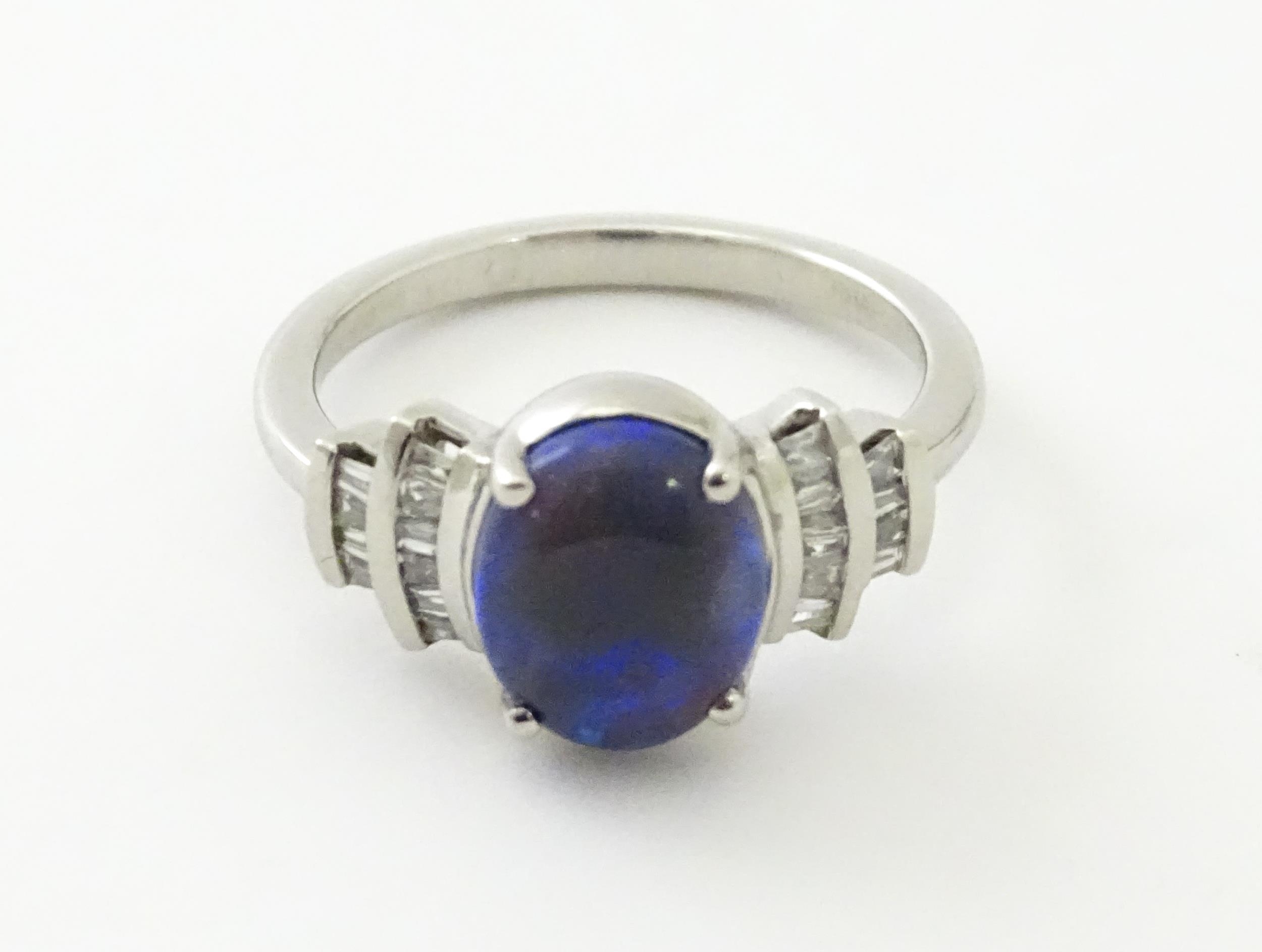 A platinum ring set with central black opal cabochon flanked by diamonds in an Art deco style - Image 3 of 9