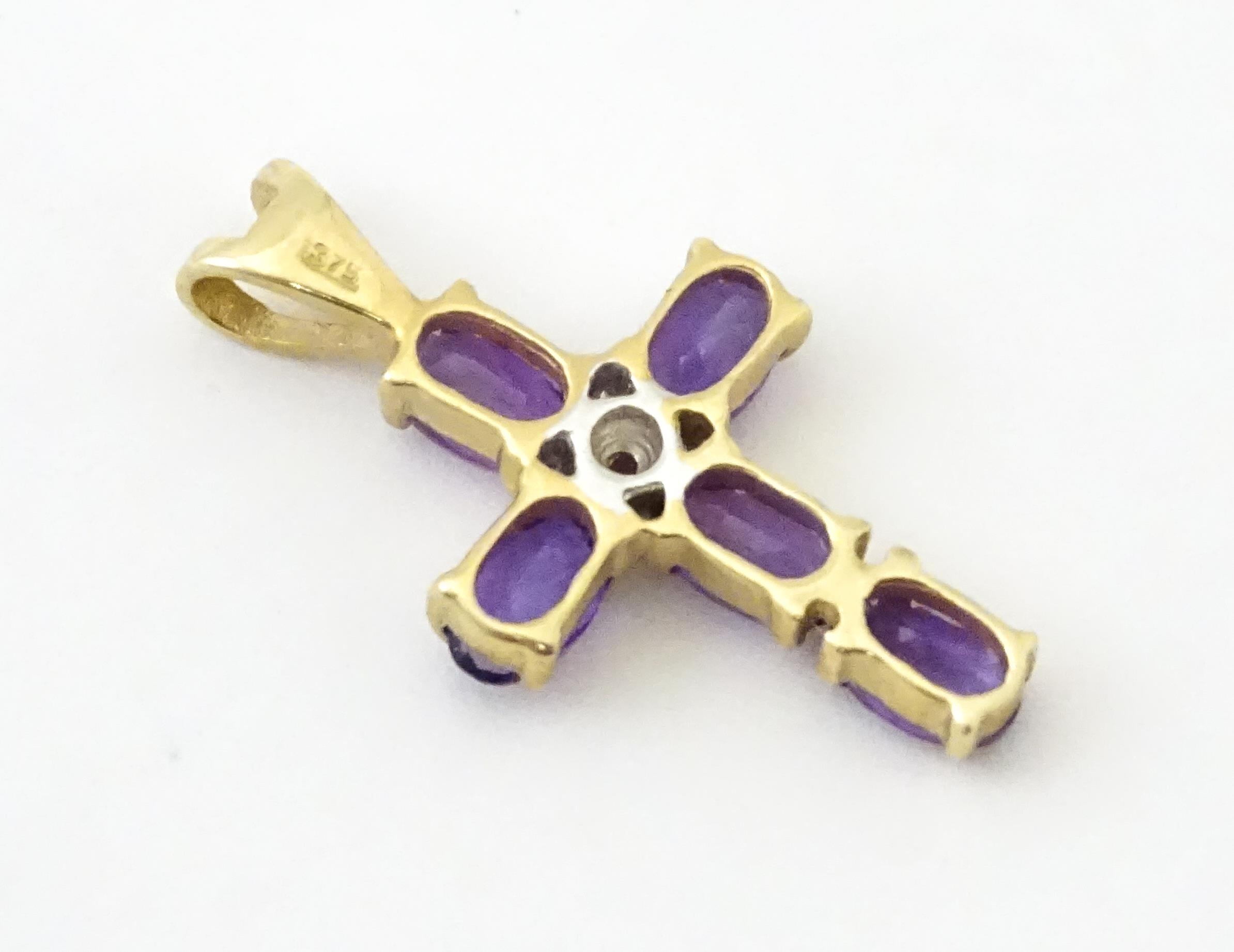 A 9ct gold cross formed pendant set with amethyst and central diamond. Approx. 1" long Please Note - - Image 5 of 6