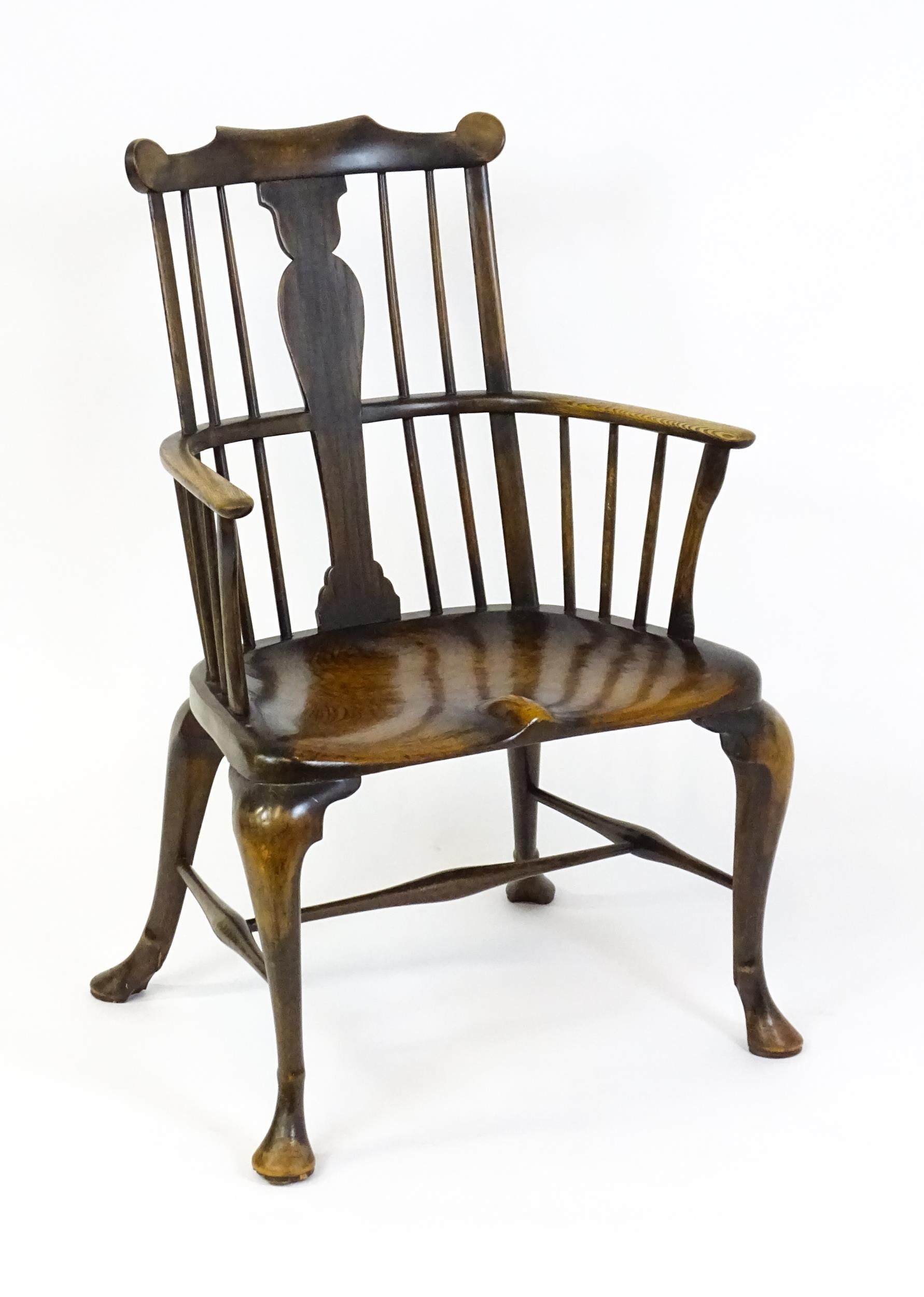 A late 19thC / early 20thC comb back Windsor chair with a vase shaped back splat and an unusually