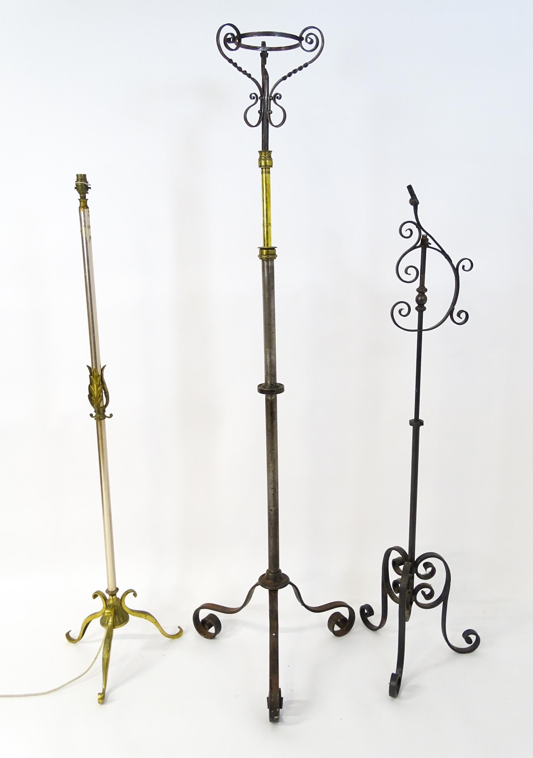 A 20thC standard lamp with triform base and foliate decoration. Together with two wrought iron style