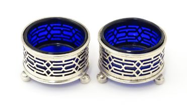 A pair of Victorian silver salts with pierced decoration and blue glass liners, hallmarked