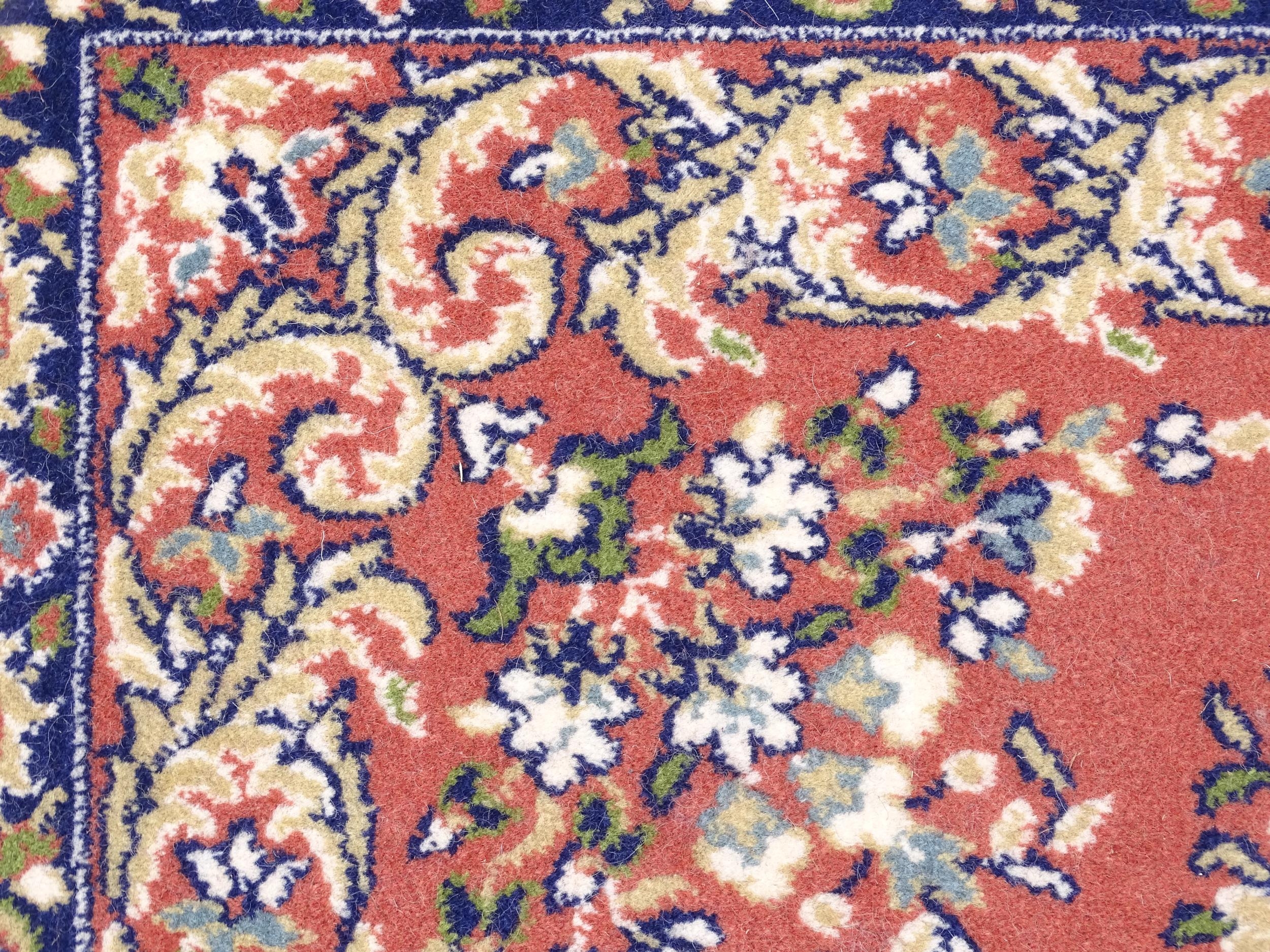 Carpet / Rug : A red ground rug with central floral motif, bordered by floral and foliate scroll - Image 4 of 7