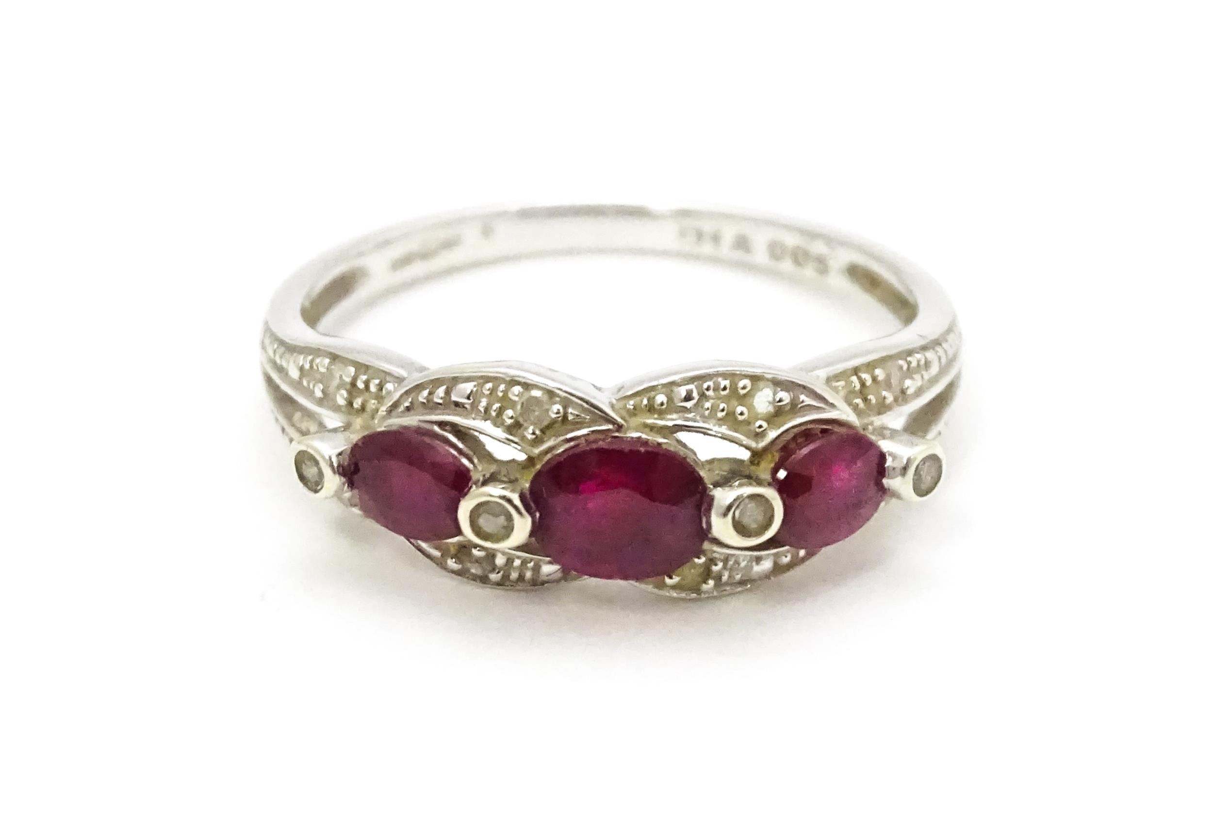 A 9ct white gold ring set with rubies and diamond. Ring size approx. M 1/2 Please Note - we do not