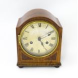 An early 20thC German walnut cased mantle clock with burr walnut veneered detail and satinwood