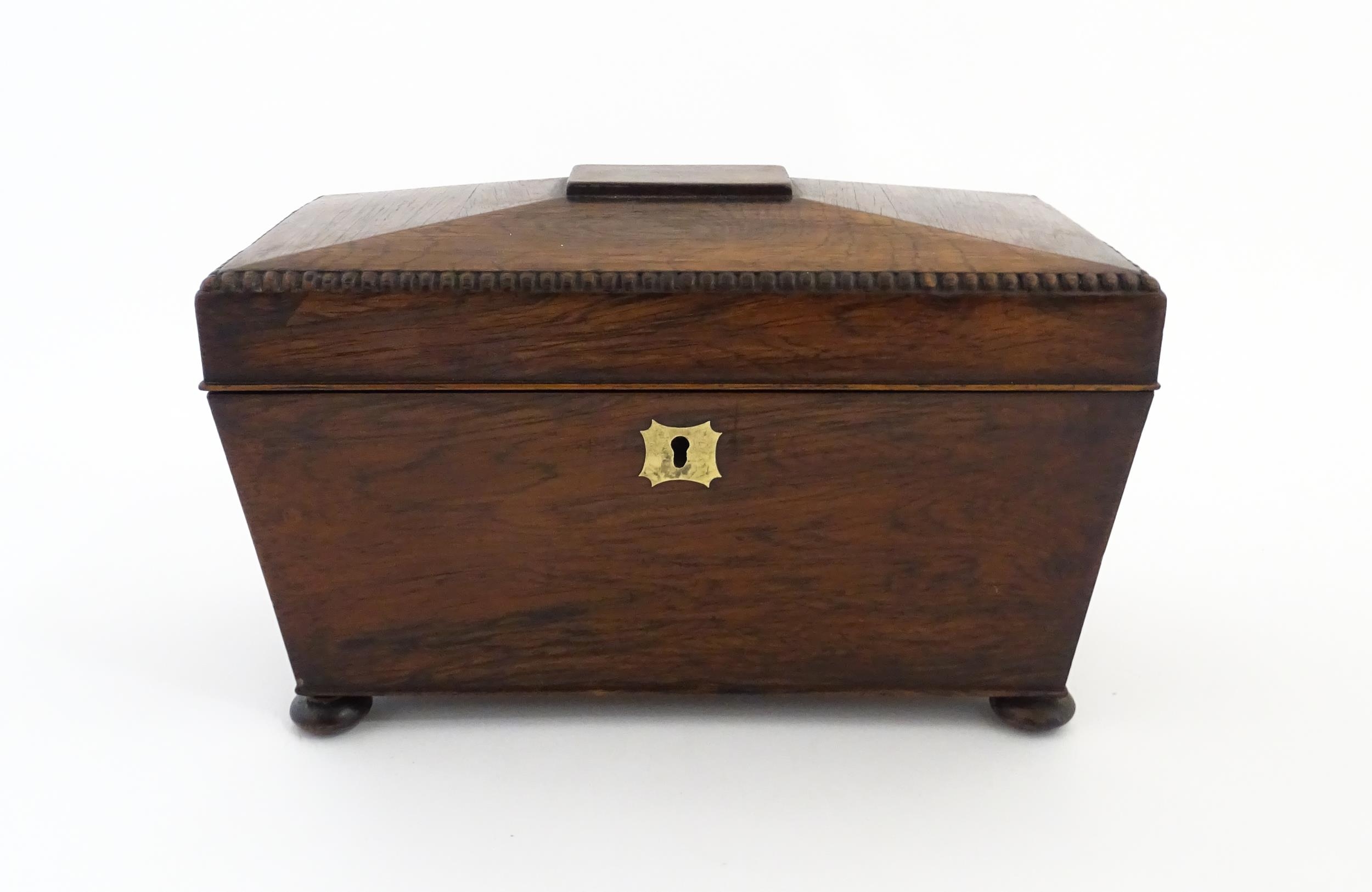 A 19thC rosewood tea caddy of sarcophagus form with four squat bun feet. The interior with two - Image 2 of 15