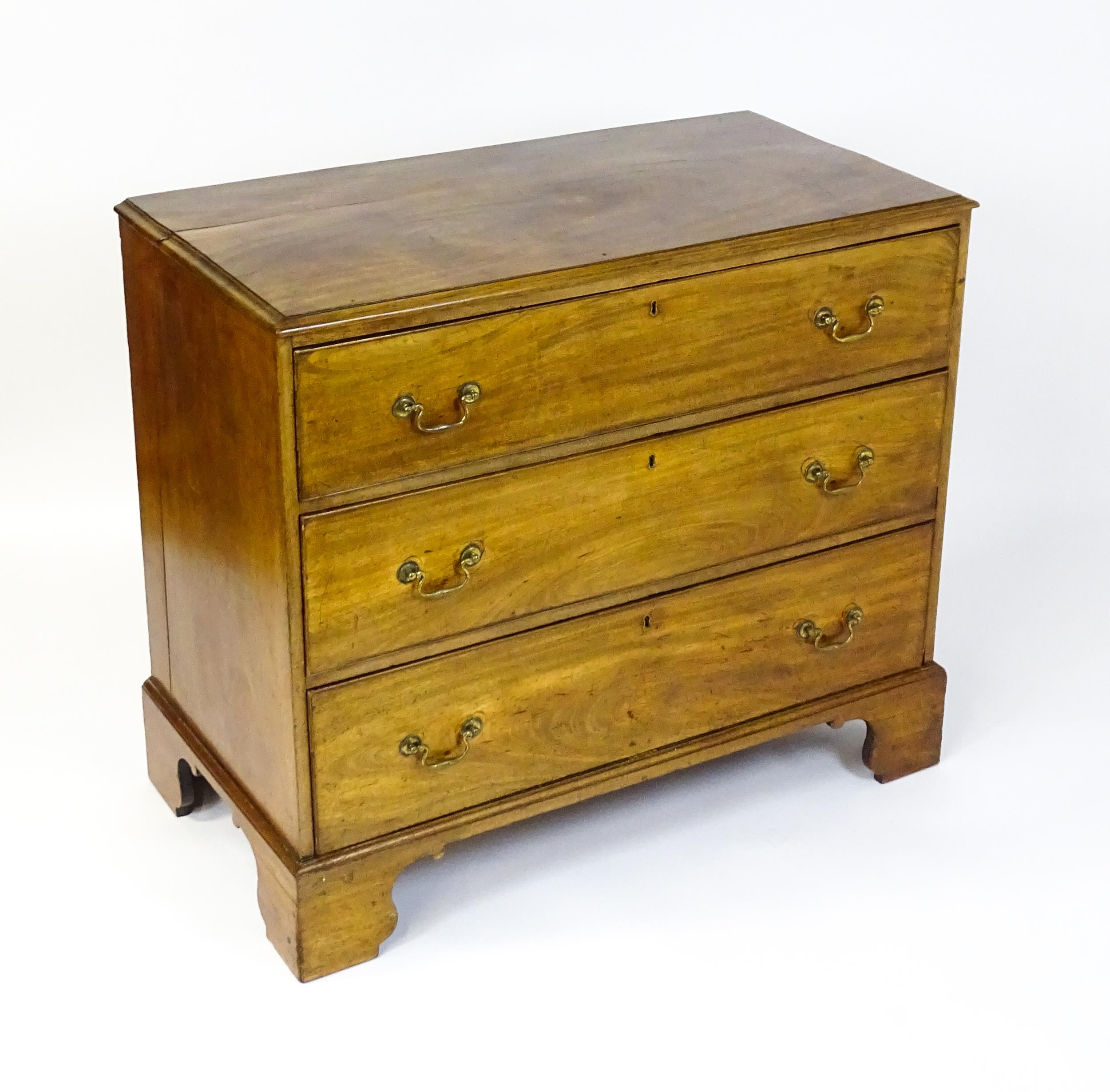 A late Georgian mahogany chest of drawers with a rectangular moulded top above three long drawers - Image 3 of 10