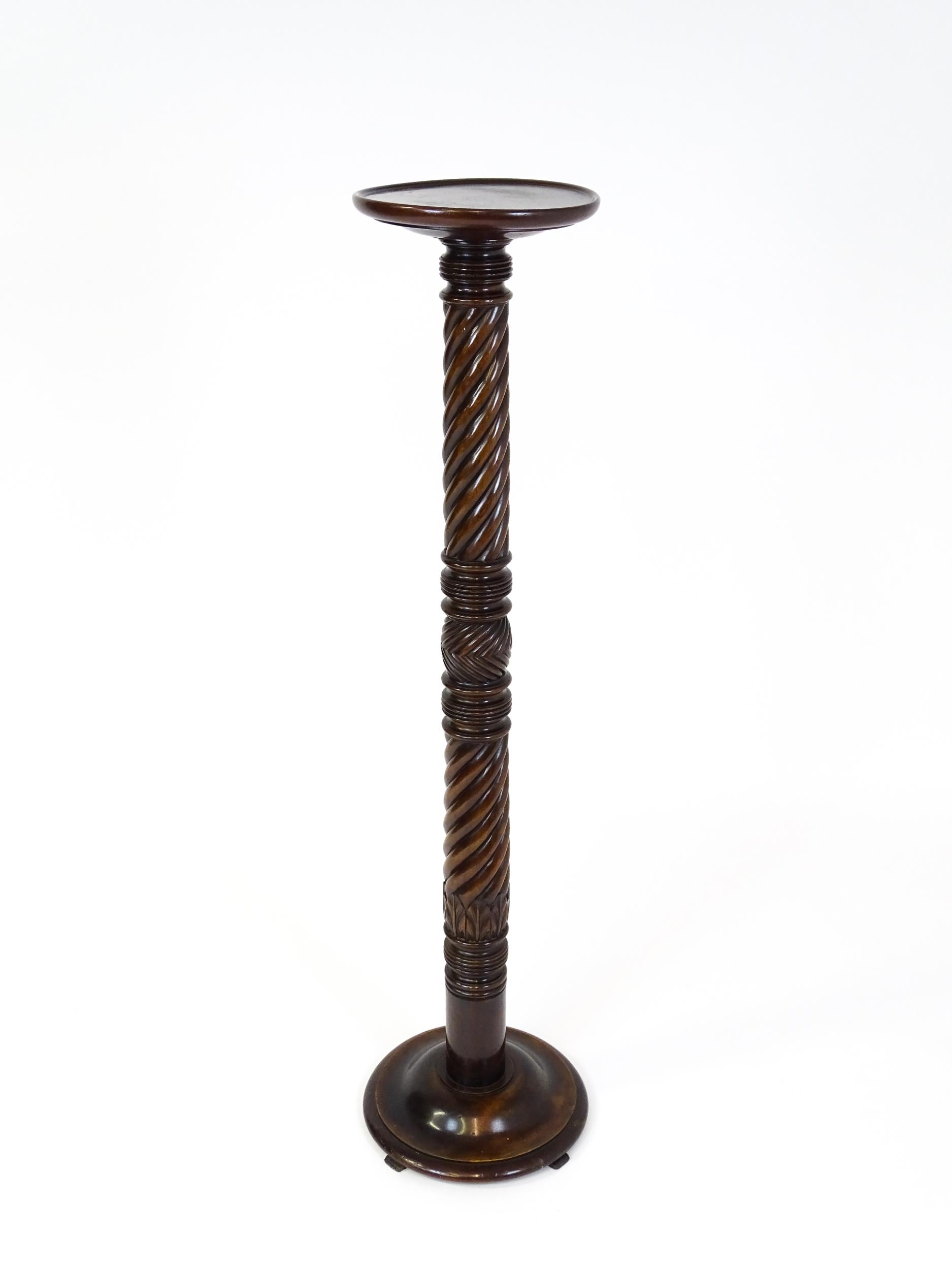 A Victorian mahogany torchiere / jardinière stand with a twist turned pedestal with carved