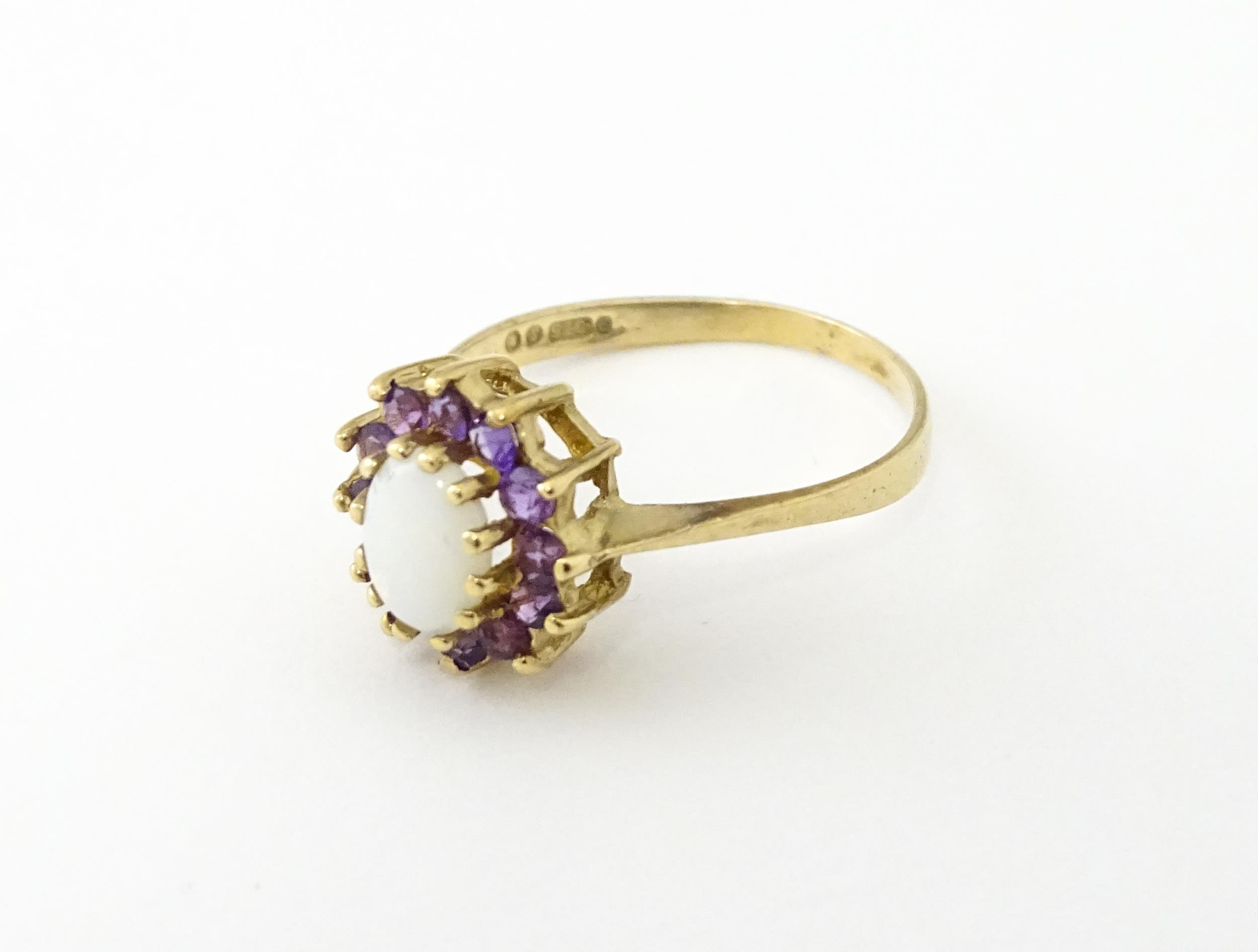 A 9ct gold ring set with central opal bordered by amethysts. Ring size approx. M Please Note - we do - Image 3 of 7