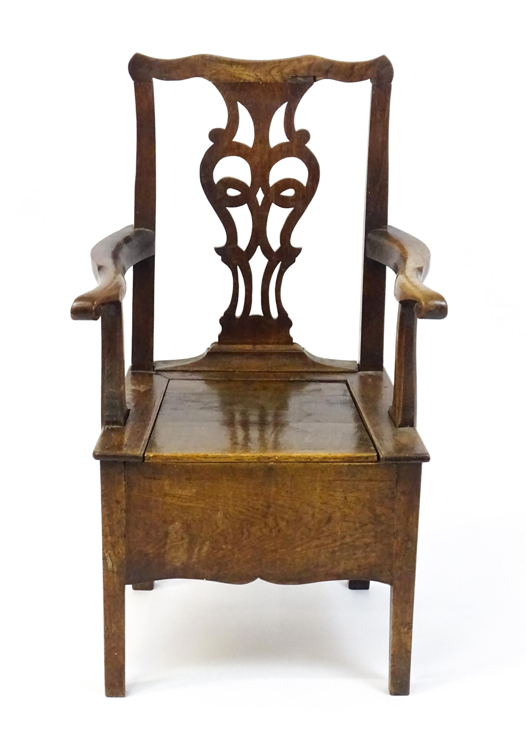 A late Georgian oak commode chair with a Chippendale style back splat above a hinged seat opening to - Image 4 of 10