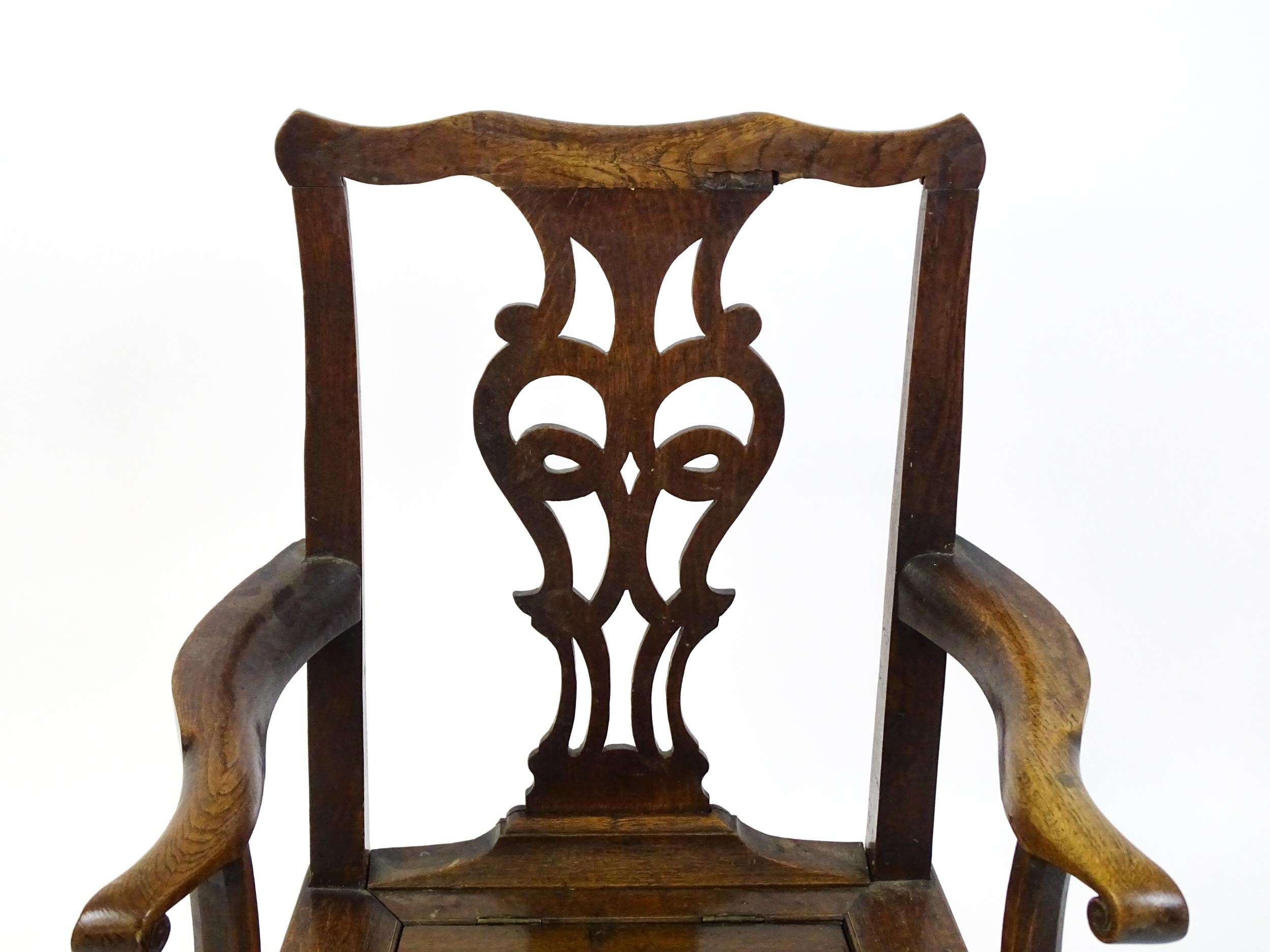 A late Georgian oak commode chair with a Chippendale style back splat above a hinged seat opening to - Image 6 of 10