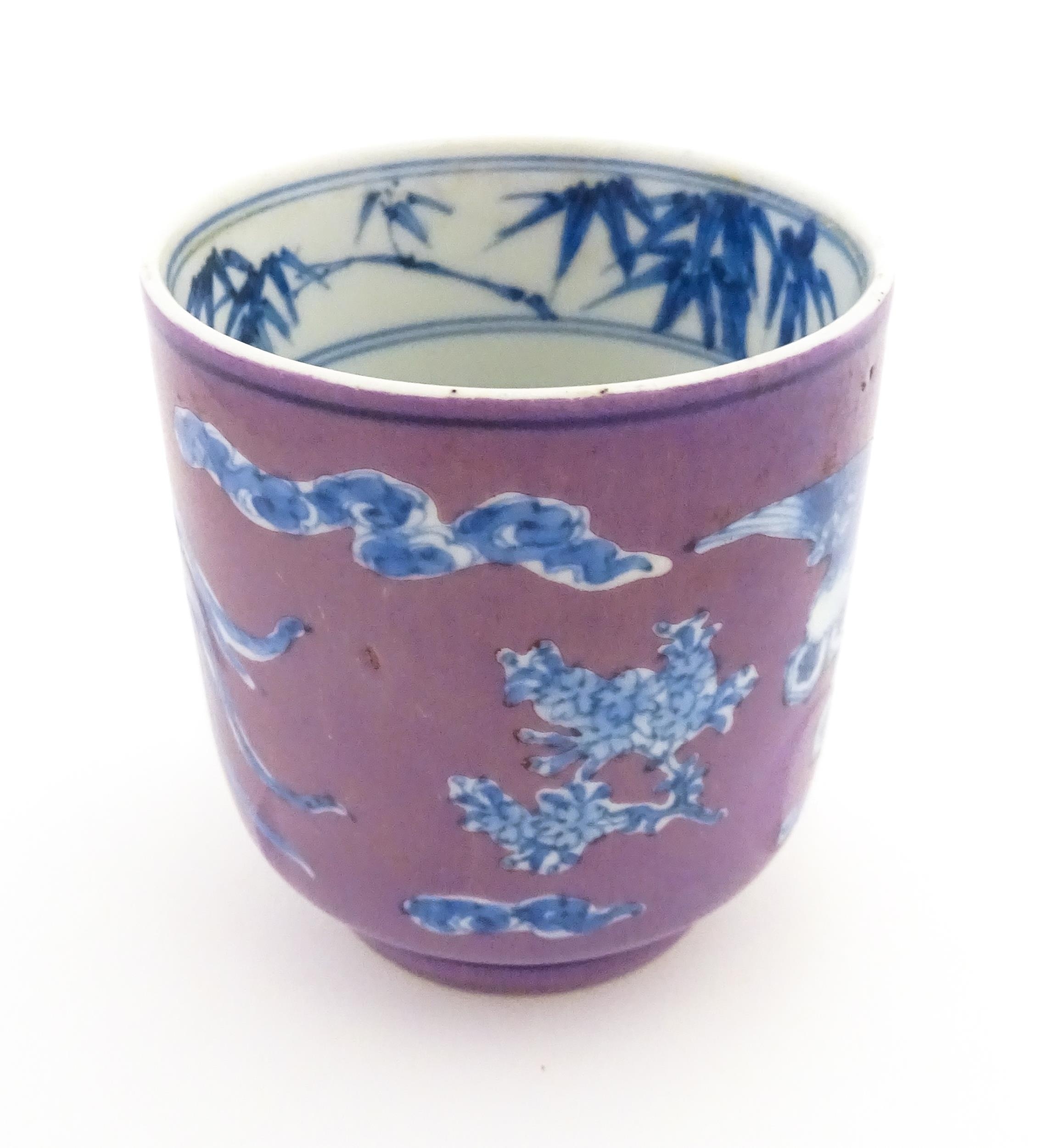 A Chinese cup with a purple ground decorated with birds, foliage and stylised clouds. Character - Image 3 of 8