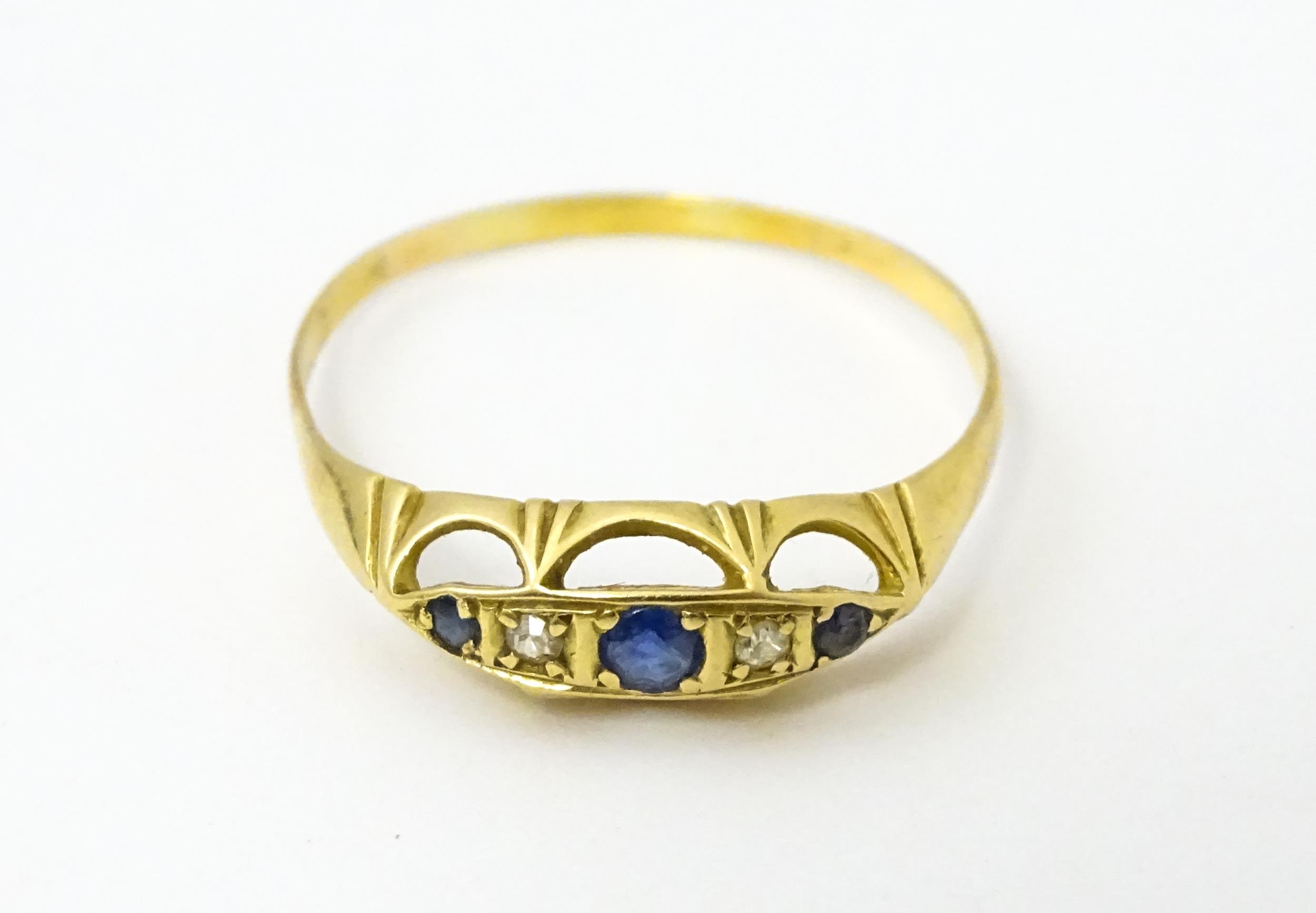 A gold ring set with diamonds and sapphires. Ring size approx. X Please Note - we do not make