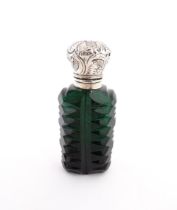 A green cut glass scent / perfume bottle with stopper. Approx. 3" high Please Note - we do not
