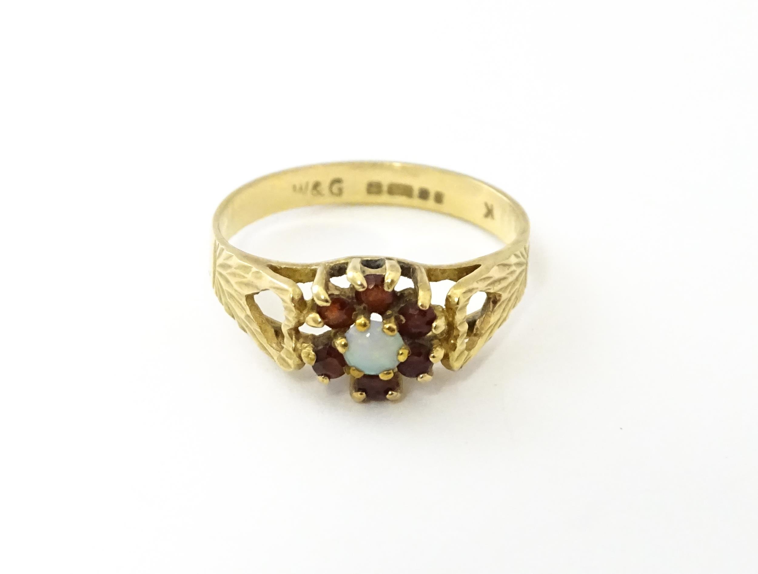 A 9ct gold ring set with central opal bordered by 6 garnets. Ring size approx. L Please Note - we do - Image 3 of 8