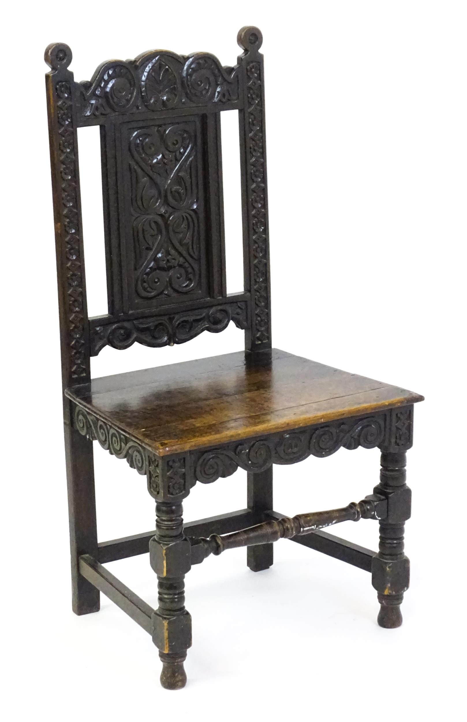 A 19thC carved oak side chair with floral carving, a planked seat and raised on block and turned - Image 5 of 6