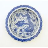 A Chinese blue and white bowl / dish decorated with a dragon and flaming pearl amongst stylised