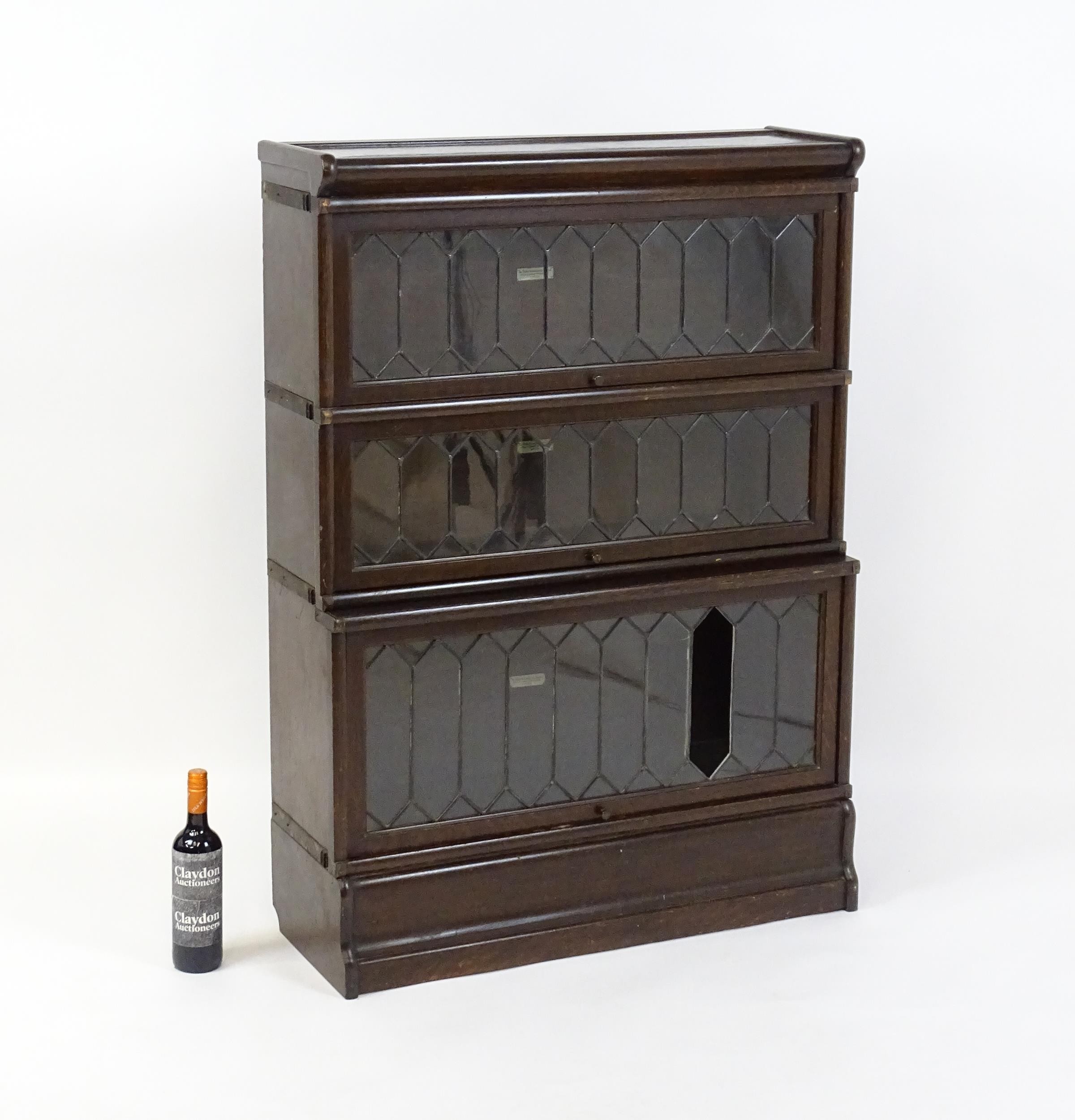 An early / mid 20thC oak Globe Wernicke bookcase with three glazed tiers above a shaped base. 34" - Image 2 of 8