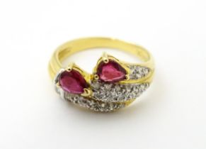 An 18ct gold ruby and diamond ring set with two rubies and a profusion of diamonds. Ring size