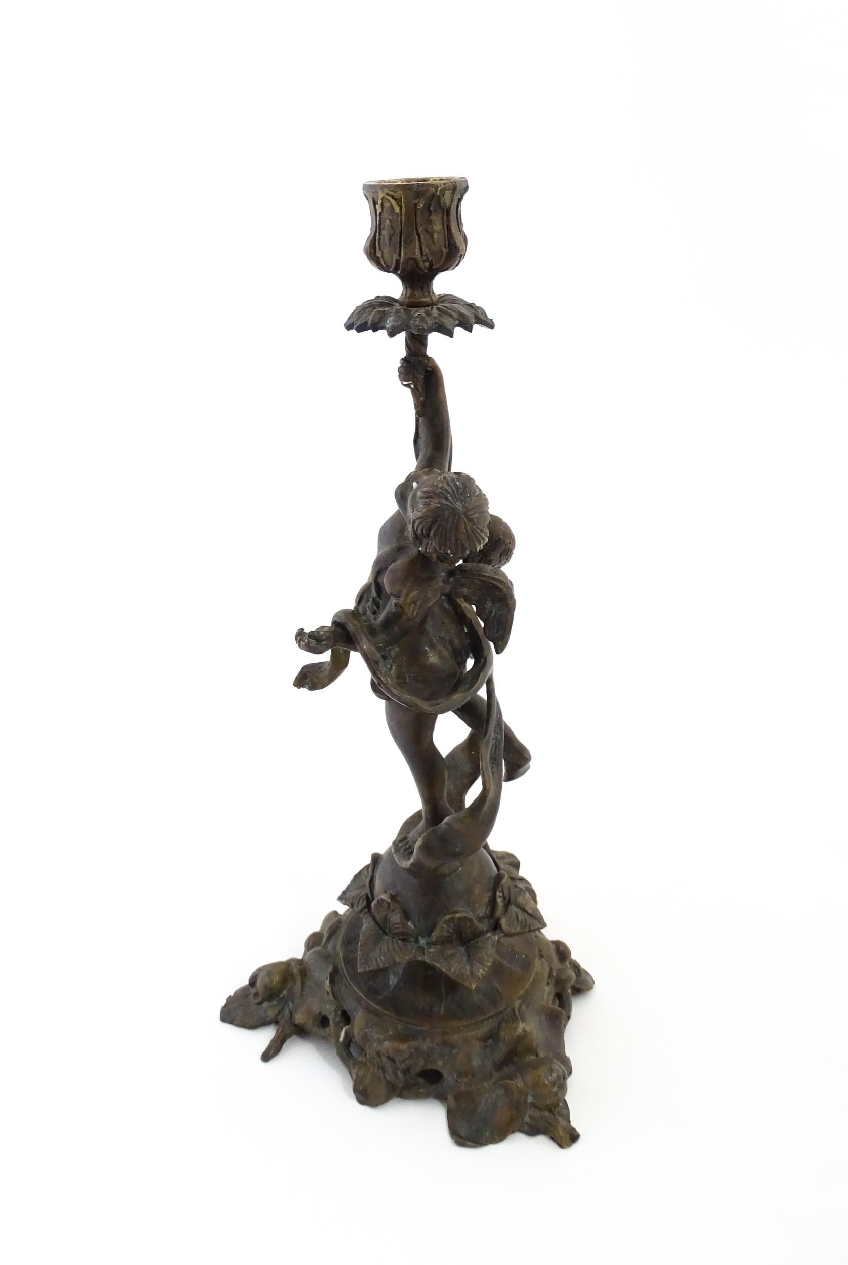 An early 20thC cast candlestick modelled as a winged putto / cherub holding aloft a sconce with - Image 4 of 6