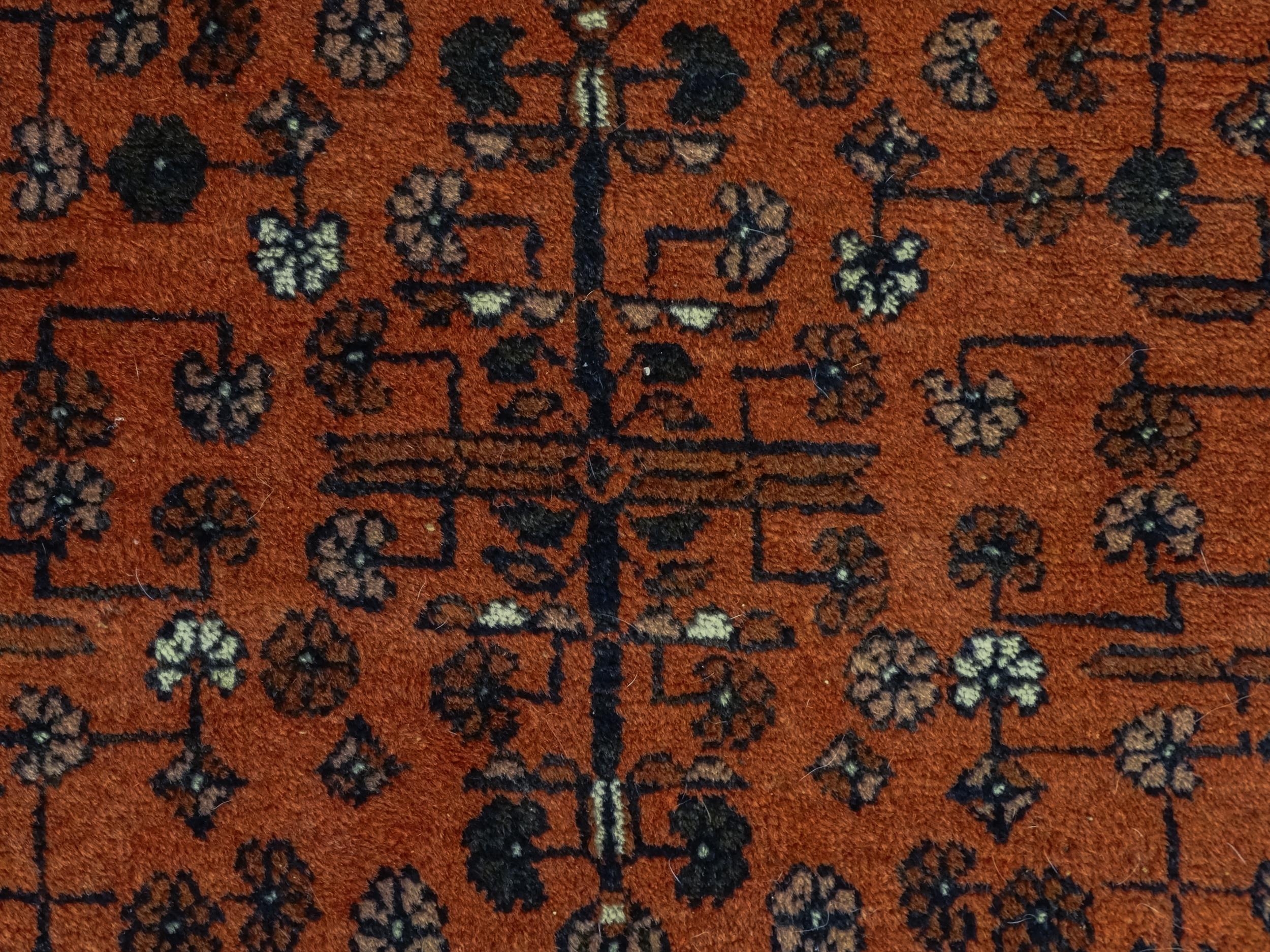 Carpet / Rug: A red ground rug decorated with floral and foliate detail, further repeated to - Image 7 of 8