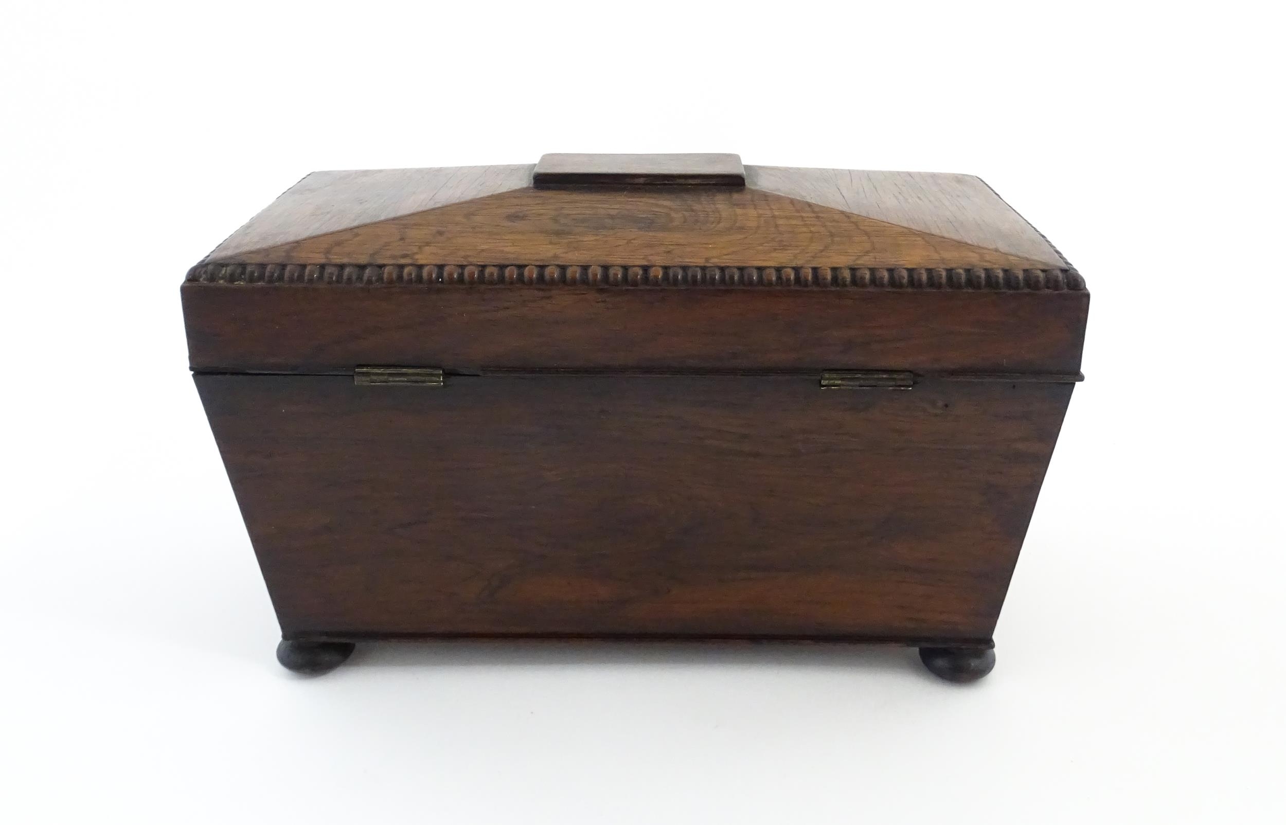 A 19thC rosewood tea caddy of sarcophagus form with four squat bun feet. The interior with two - Image 5 of 15