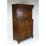 A late 18thC oak Welsh dueddarn cupboard with a moulded cornice above two panelled doors and base