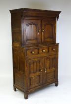 A late 18thC oak Welsh dueddarn cupboard with a moulded cornice above two panelled doors and base