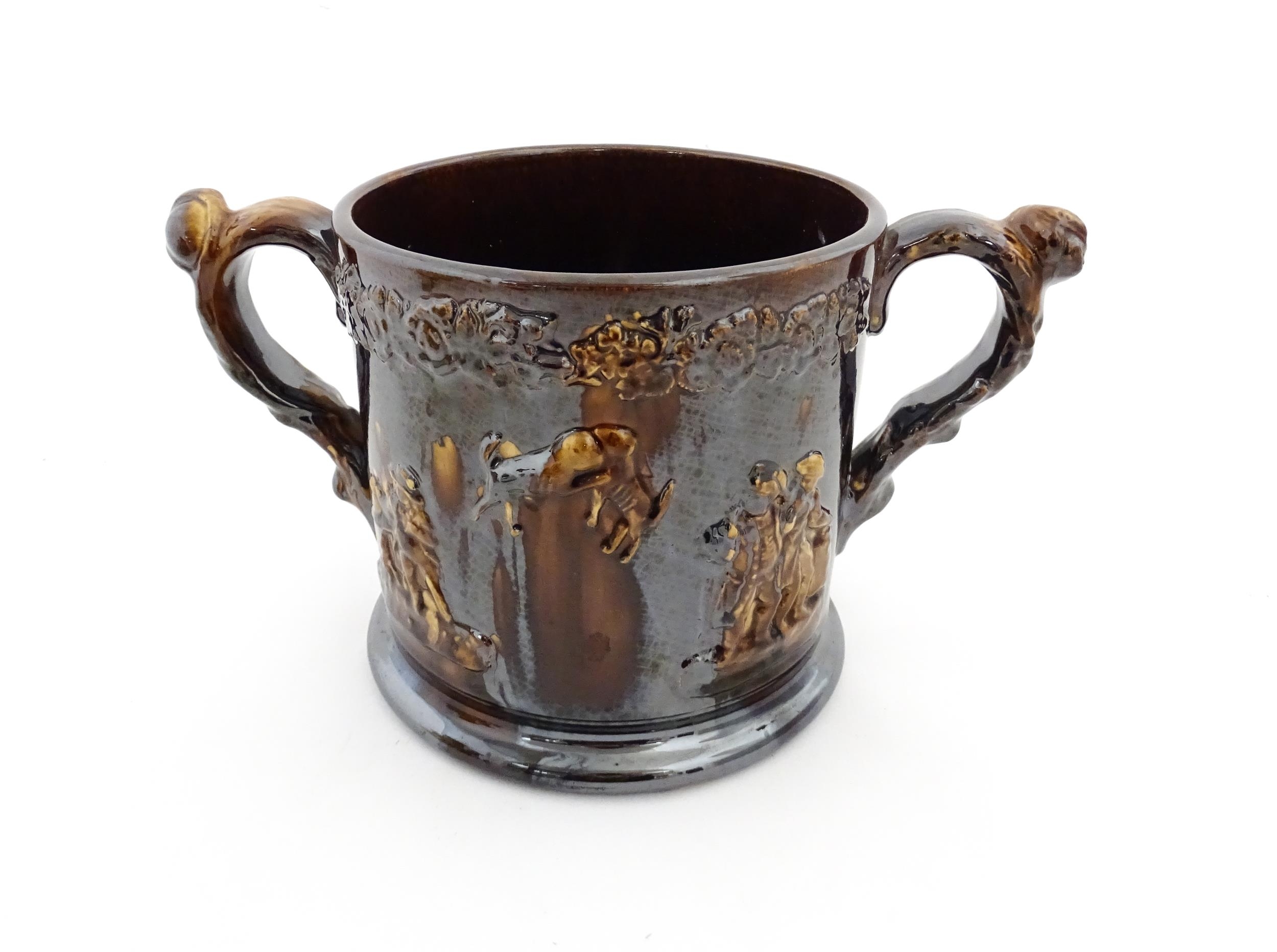 A large Staffordshire treacle glazed frog loving cup decorated in relief with depictions of - Image 2 of 9