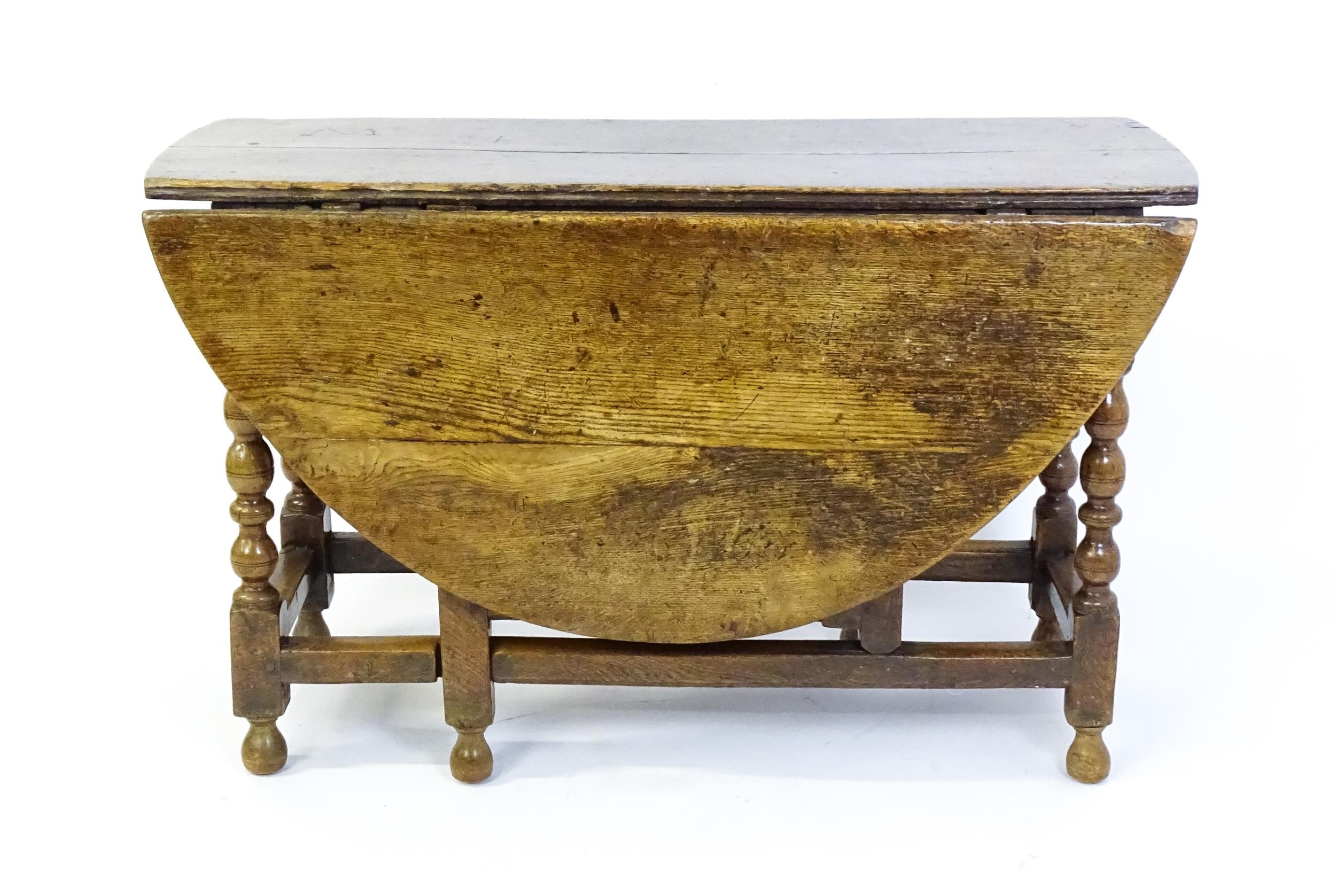An early 18thC oak drop leaf table of large proportions, the table having two demi lune leaves and - Image 2 of 6