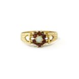 A 9ct gold ring set with central opal bordered by 6 garnets. Ring size approx. L Please Note - we do