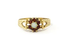 A 9ct gold ring set with central opal bordered by 6 garnets. Ring size approx. L Please Note - we do