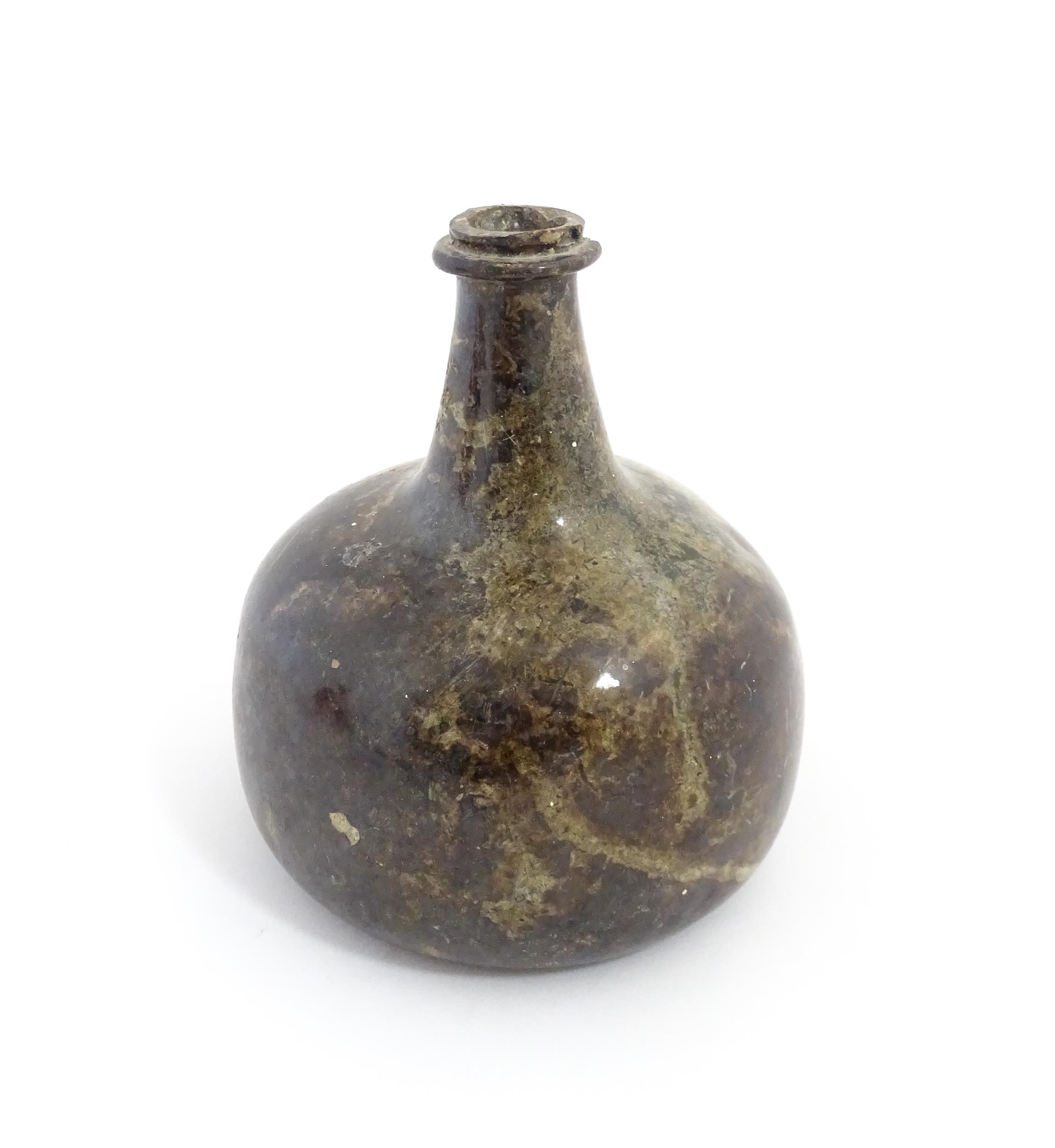 A late 18thC / early 19thC English dark olive green glass onion shape wine bottle. Approx. 6" high - Image 3 of 6