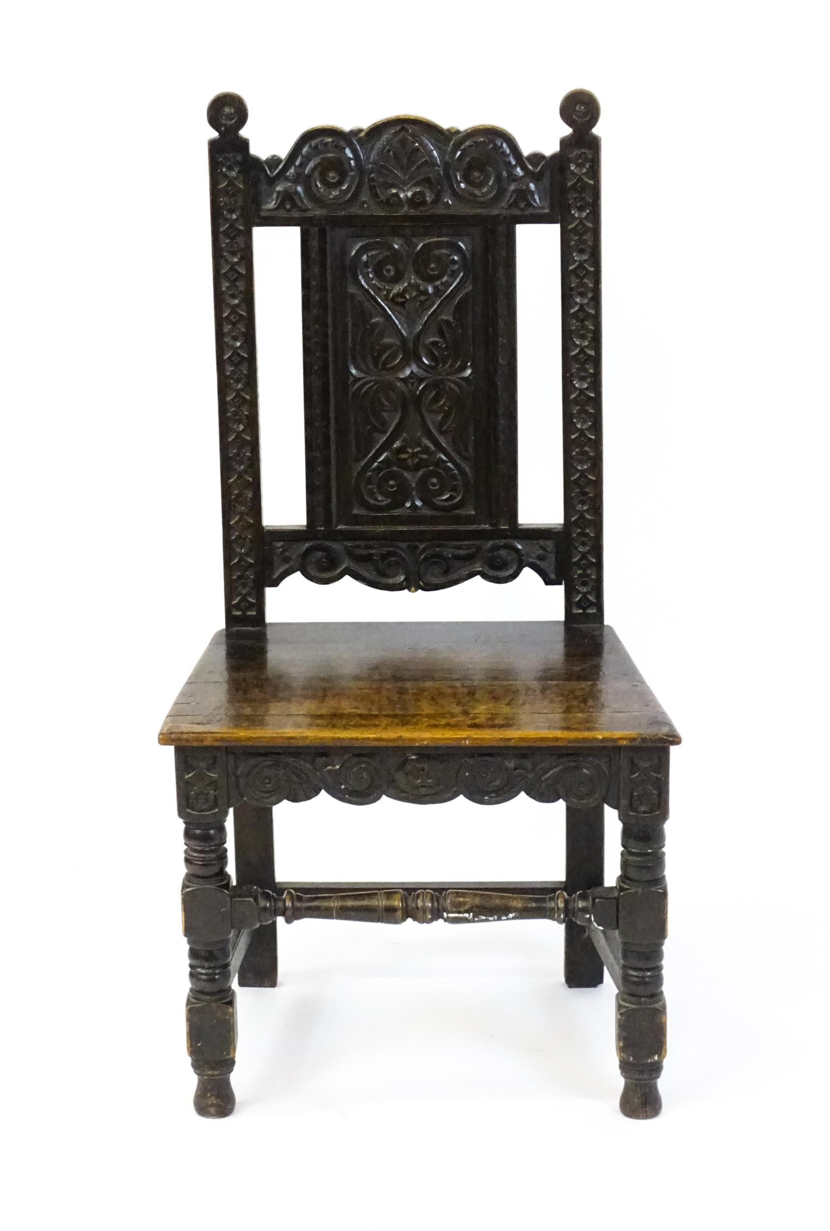 A 19thC carved oak side chair with floral carving, a planked seat and raised on block and turned - Image 2 of 6