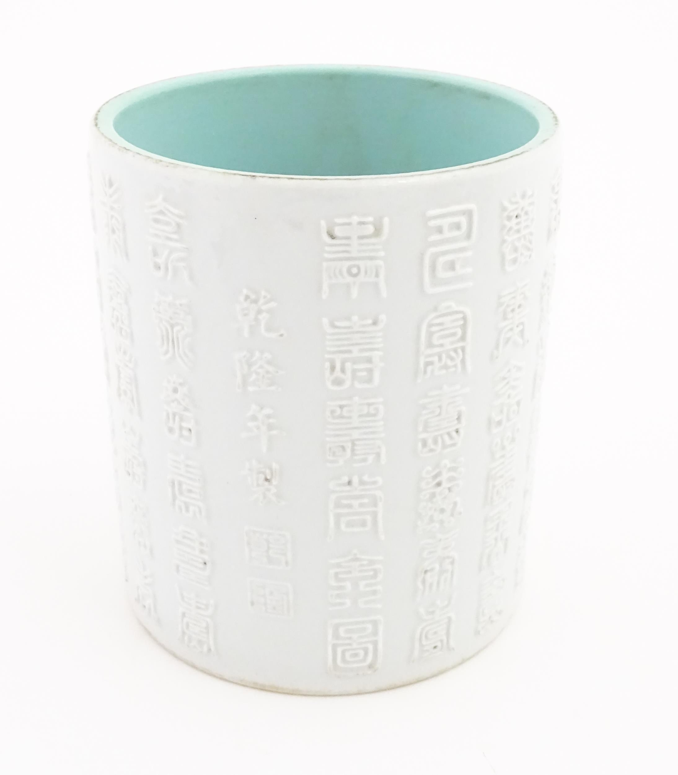 A Chinese brush pot with banded script detail in relief. Character marks under. Approx. 5 1/4"