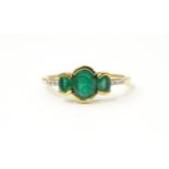 A 9ct gold ring set with three emeralds flanked by white stones. Ring size approx. M Please Note -