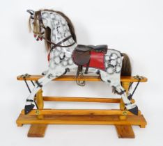 Toy: A 20thC small proportion rocking horse with painted features, leather saddle, metal stirrups