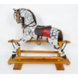 Toy: A 20thC small proportion rocking horse with painted features, leather saddle, metal stirrups