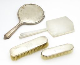 Four assorted silver backed dressing table items to include two brushes and two mirrors, to