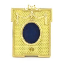 A late 20thC photograph frame with gilt metal surround with swag detail and Mozafarian emblem lower,