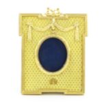 A late 20thC photograph frame with gilt metal surround with swag detail and Mozafarian emblem lower,