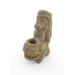 An Aztec Pre-Columbian style earthenware sculpture depicting a kneeling figure with a vessel.