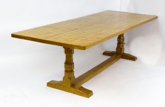 A mid 20thC Robert 'Mouseman' Thompson dining table. The 8ft long oak table top with an adzed finish