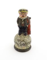 A 20thC Dunlop advertising table bell modelled as a golfer standing upon a golf ball, with