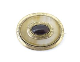 A Victorian brooch set with agate and central cabochon with yellow metal mounts. Approx 1 1/2"